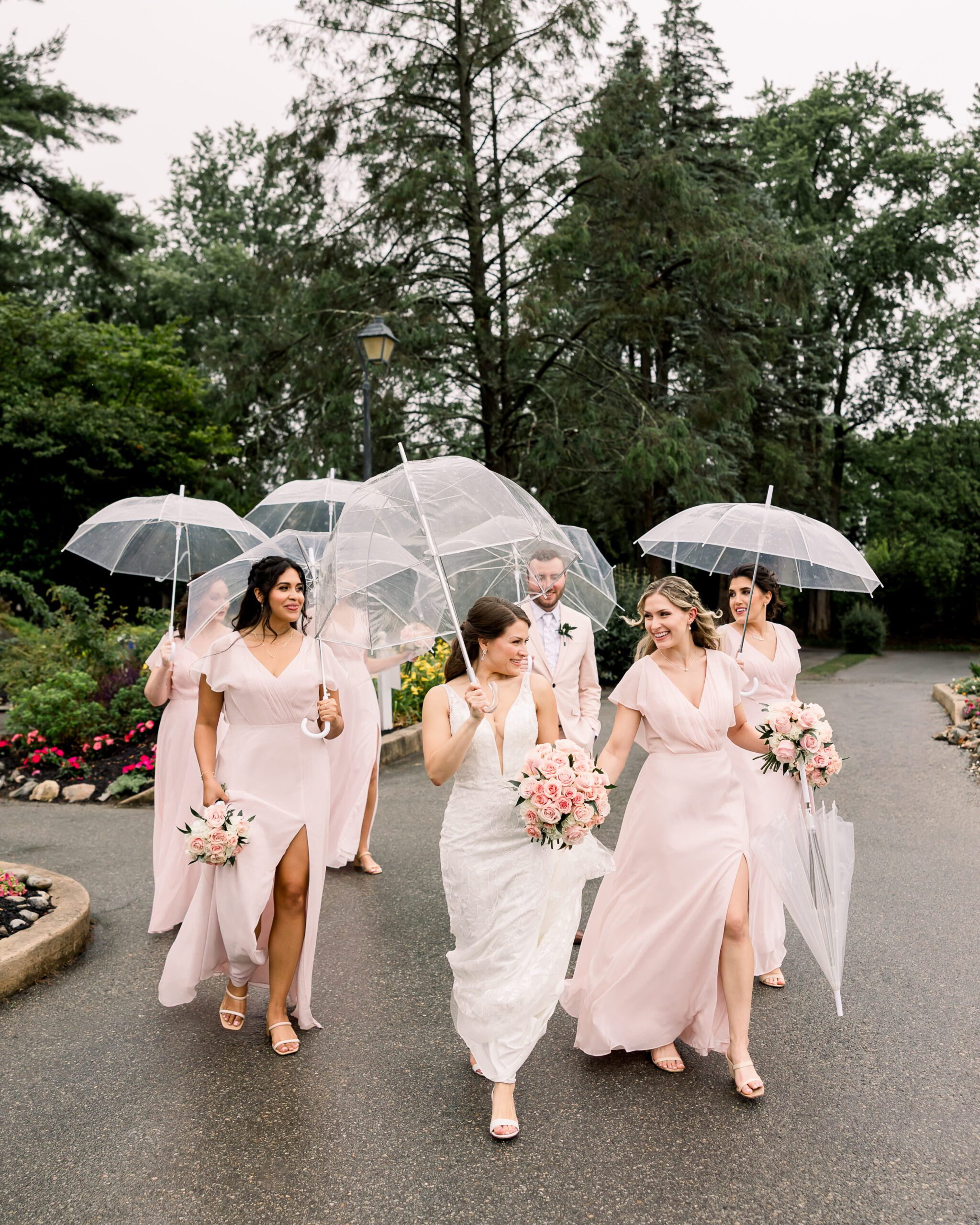 Bride and her bridal party under clear umbrellas on a rainy wedding day in Central Pennsylvania 