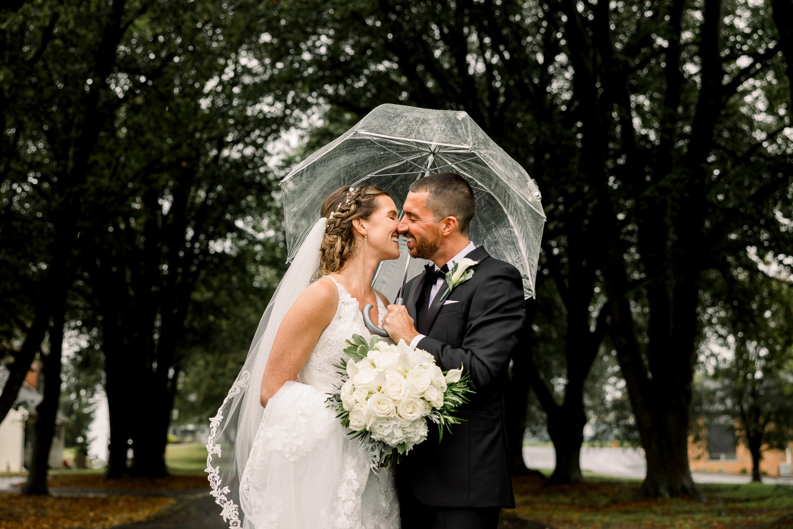Couple under a clear umbrella on a rainy wedding day in central Pennsylvania